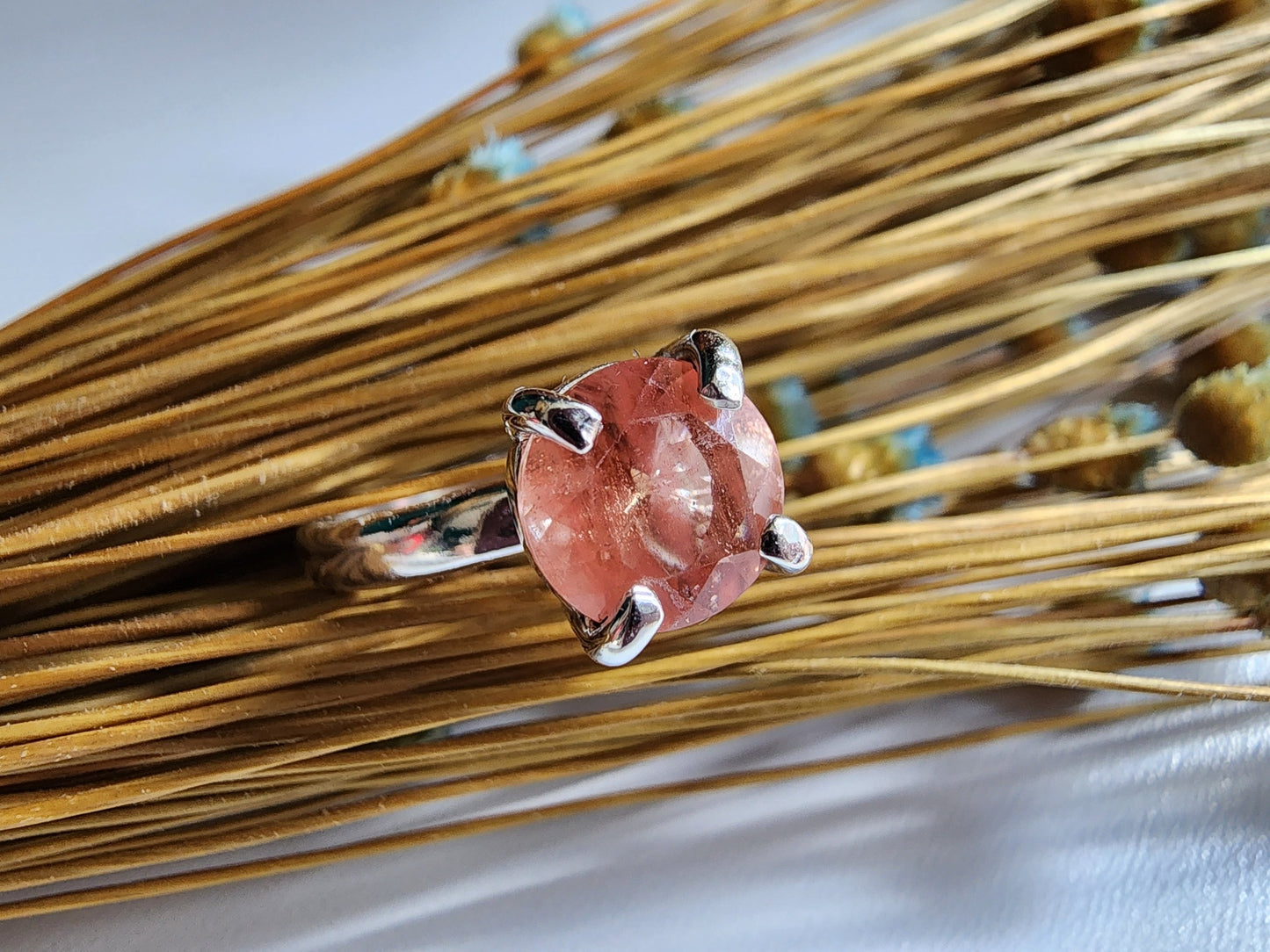 Oregon sunstone solitaire ring with pink and orange colors reflected through the stone, 4 prong set on a thick silver band for resilience 