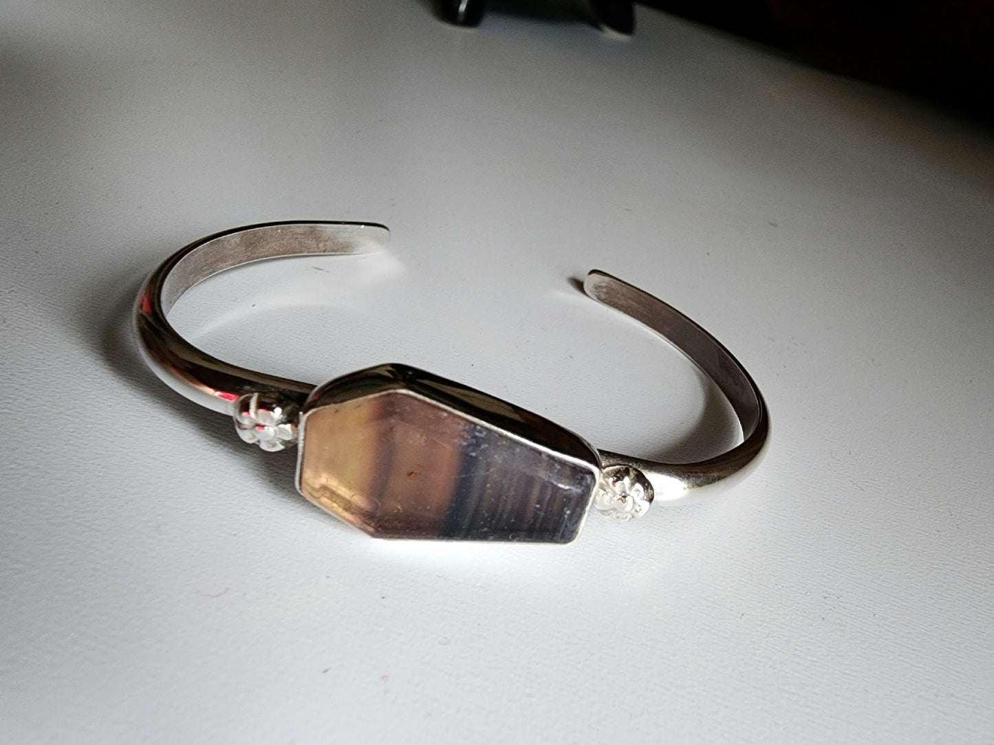 Fluorite coffin stone cuff with small botanical flowers on the left and right mounted on a sterling silver cuff