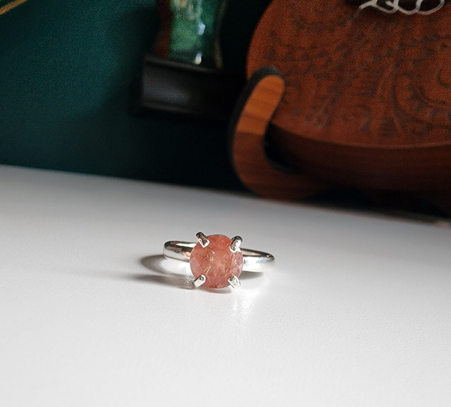 Oregon sunstone solitaire ring with pink and orange colors reflected through the stone, 4 prong set on a thick silver band for resilience
