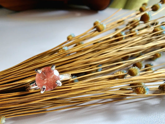 Oregon sunstone solitaire ring with pink and orange colors reflected through the stone, 4 prong set on a thick silver band for resilience