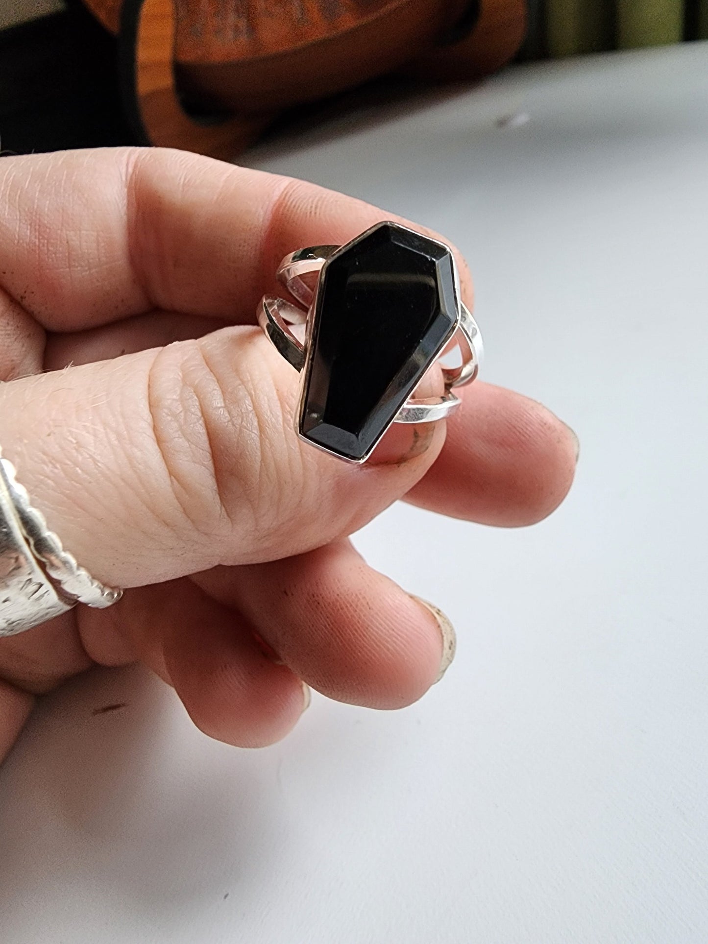 Split shank coffin stone ring with onyx stone. Two silver band extend on the left and right