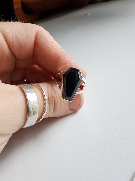 Split shank coffin stone ring with onyx stone. Two silver band extend on the left and right