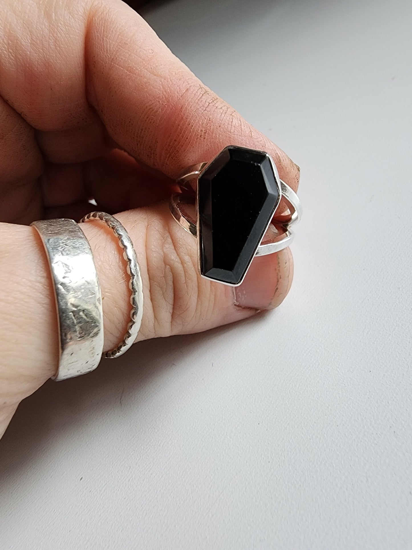 Split shank coffin stone ring with onyx stone. Two silver band extend on the left and right