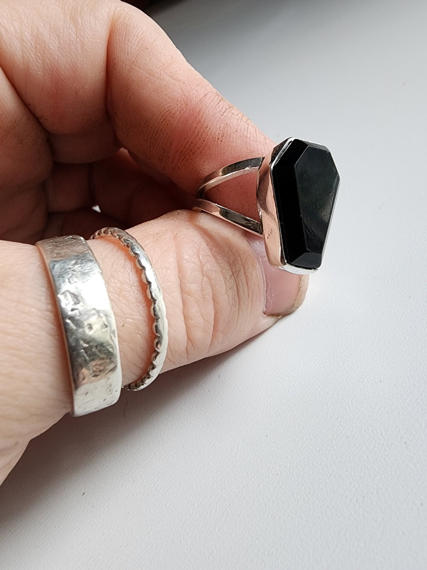 Split shank coffin stone ring with onyx stone. Two silver band extend on the left and right