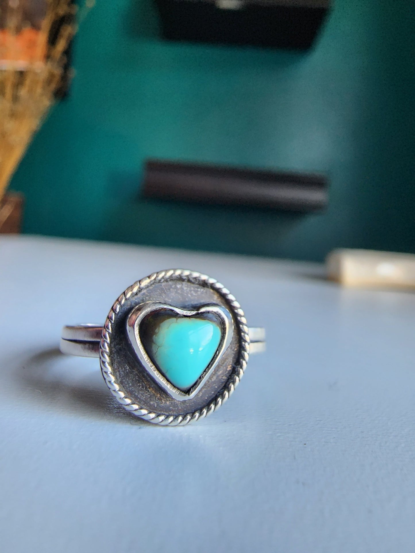 Kingman heart ring with blacked out surround and twisted wire going around. Ring is .925 sterling silver with a double banded shank.