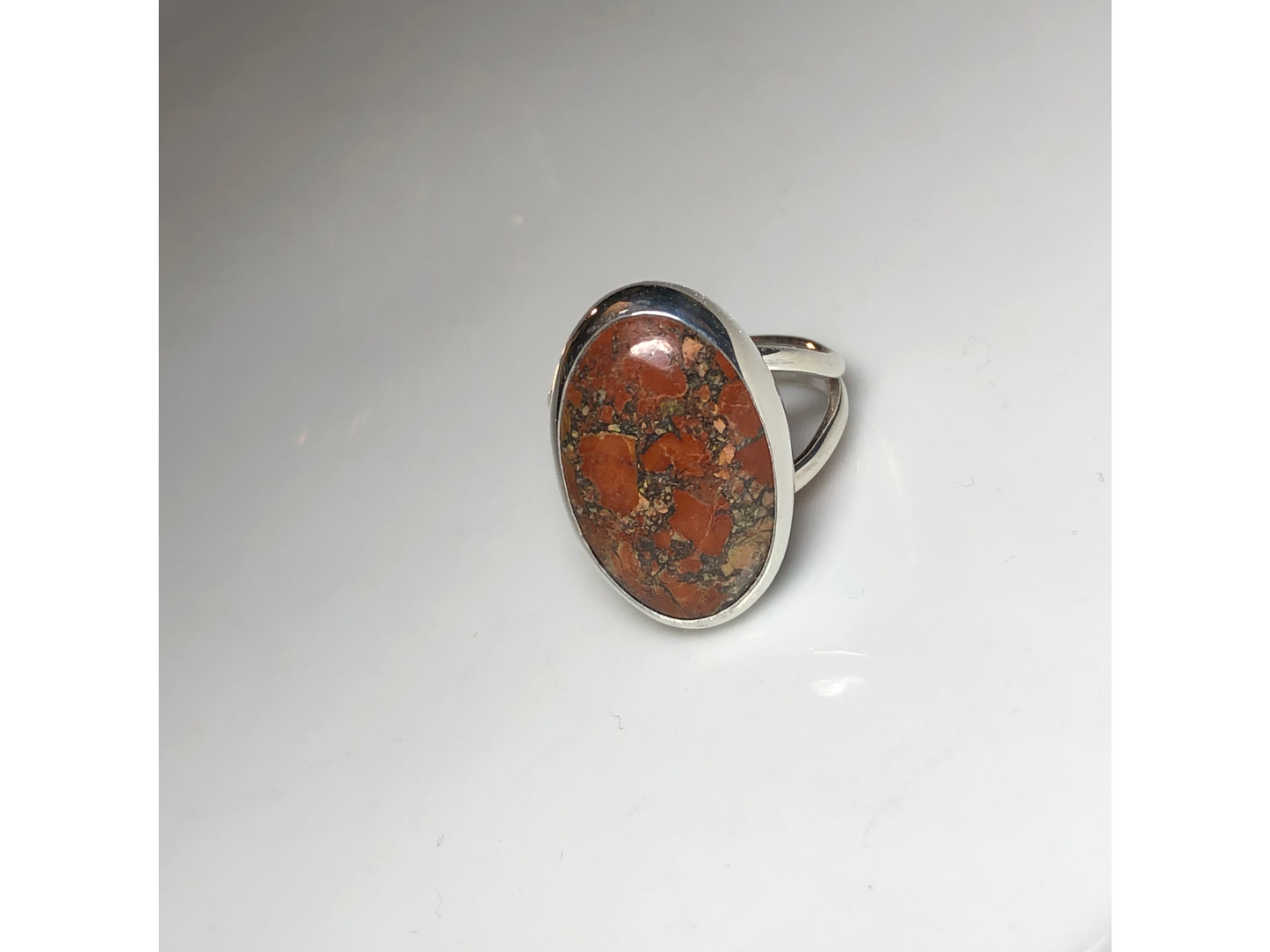 Orange, yellow and oranges grace this oval ring mounted to a simple yet sturdy band
