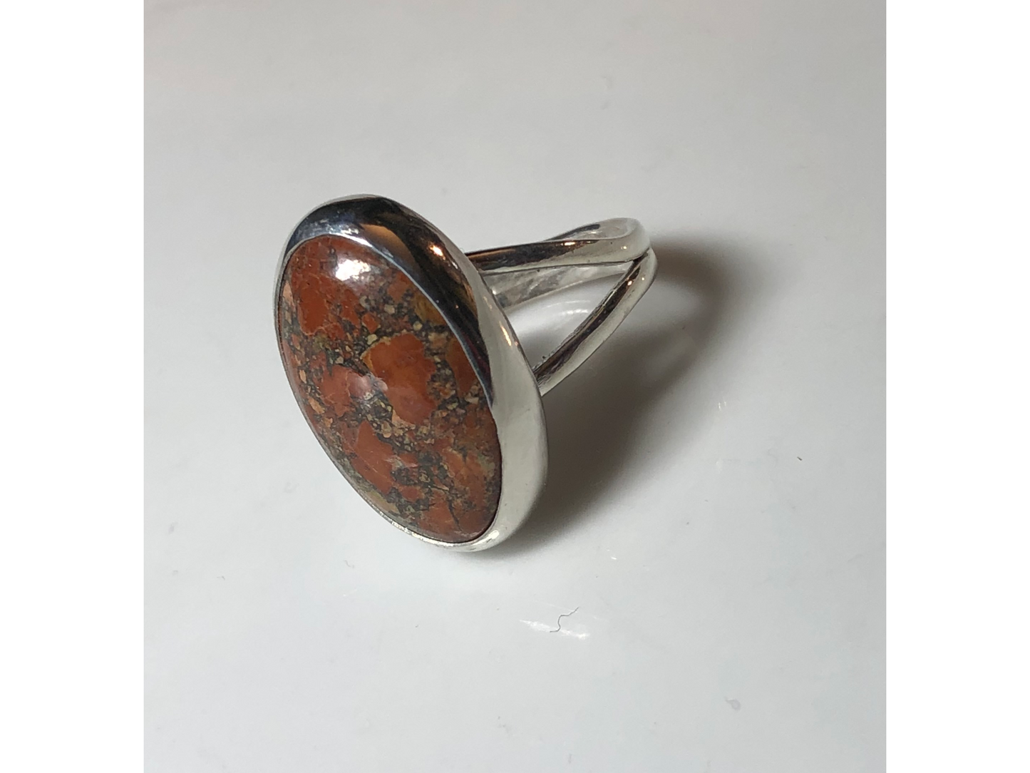 Orange, yellow and oranges grace this oval ring mounted to a simple yet sturdy band