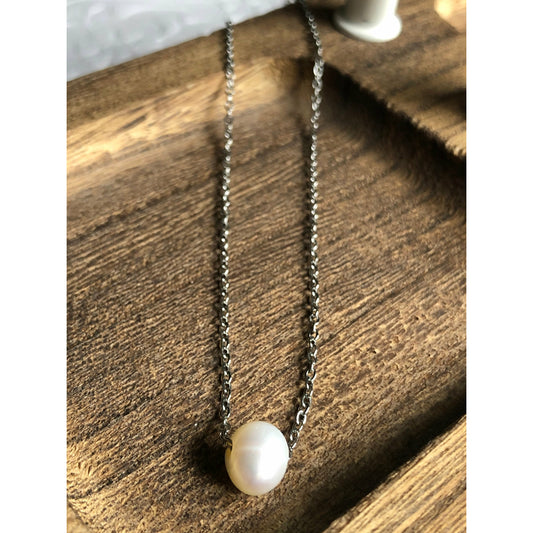 Small simple pearl with the chain of the necklace fed through it