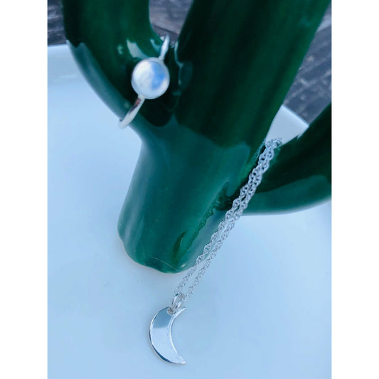 Small sliver of a moon mounted on a stainless steel chain