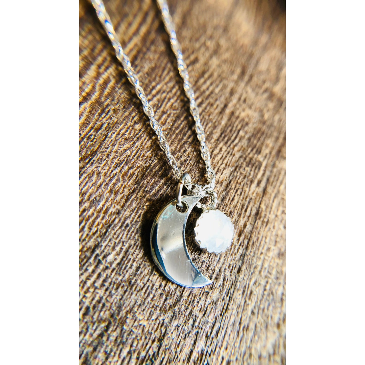 Small sliver of a moon mounted on a stainless steel chain