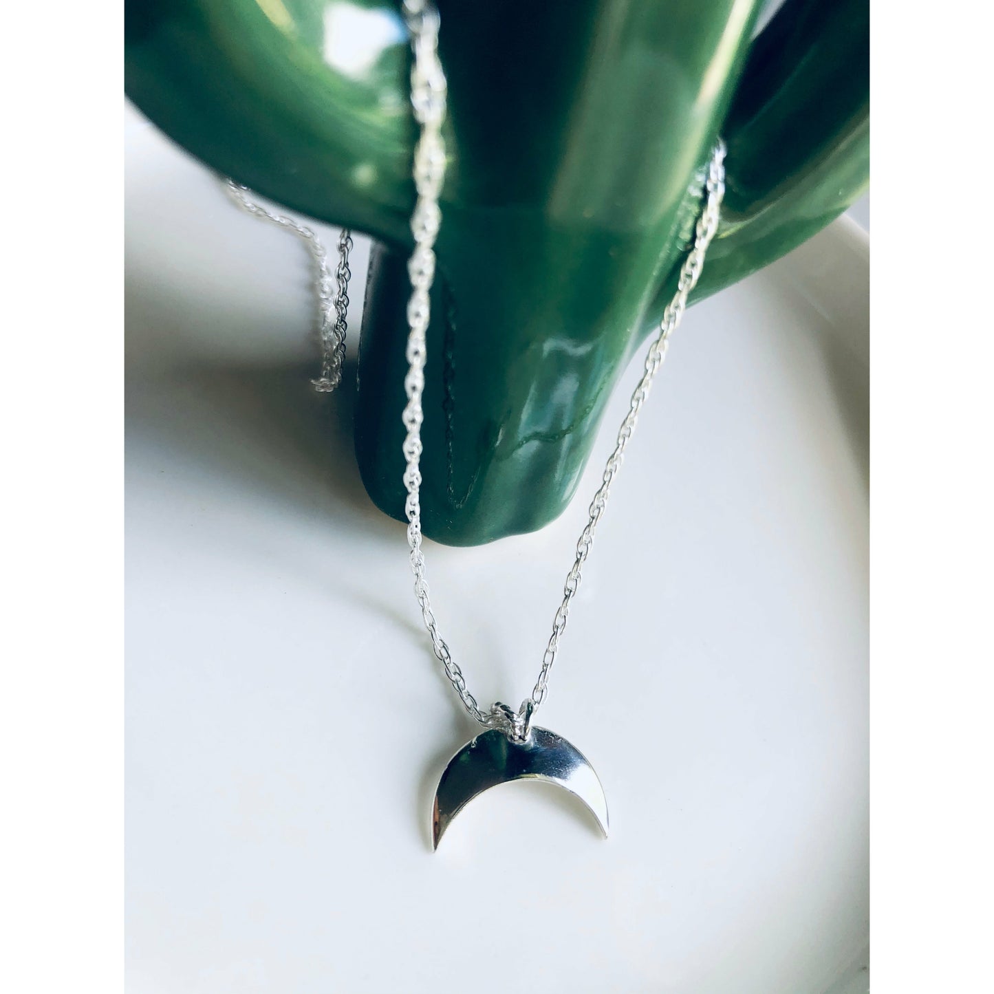 Sterling silver moon shape pointed downward mounted on a stainless steel chain