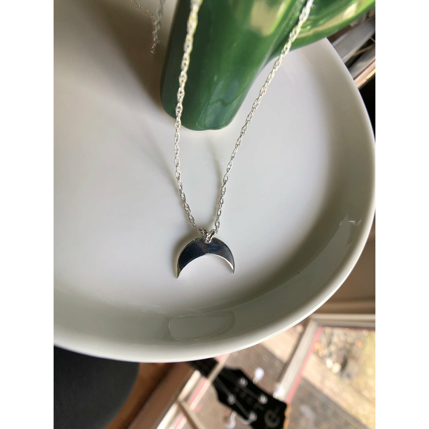 Sterling silver moon shape pointed downward mounted on a stainless steel chain