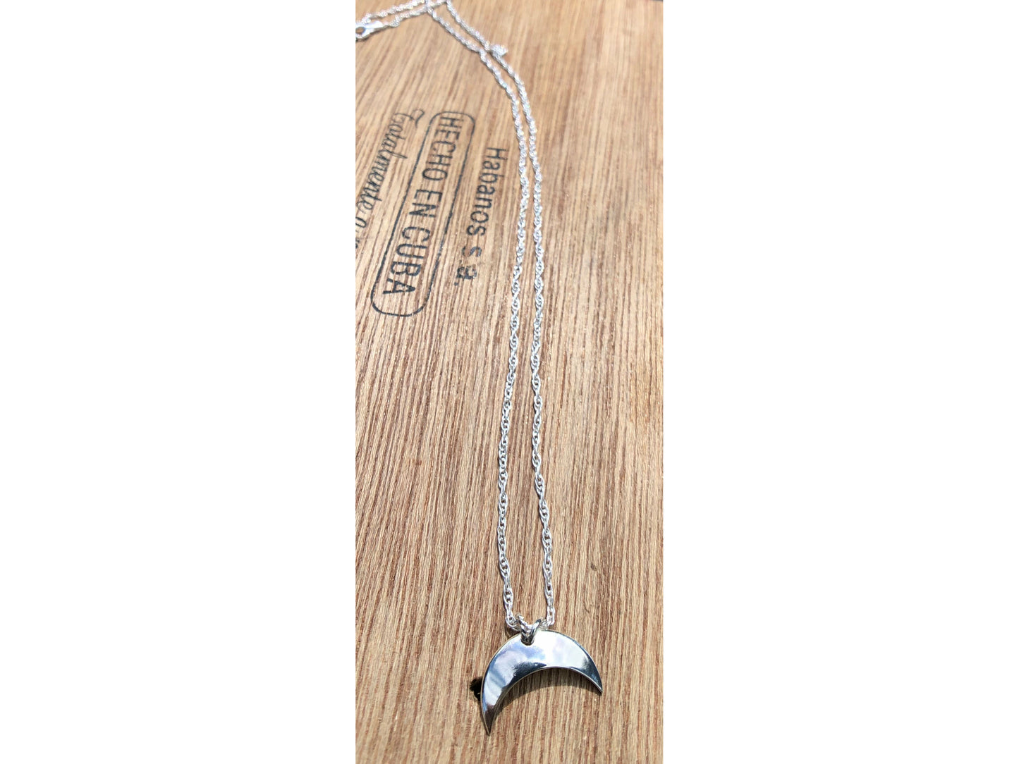 Sterling silver moon shape pointed downward mounted on a stainless steel chain