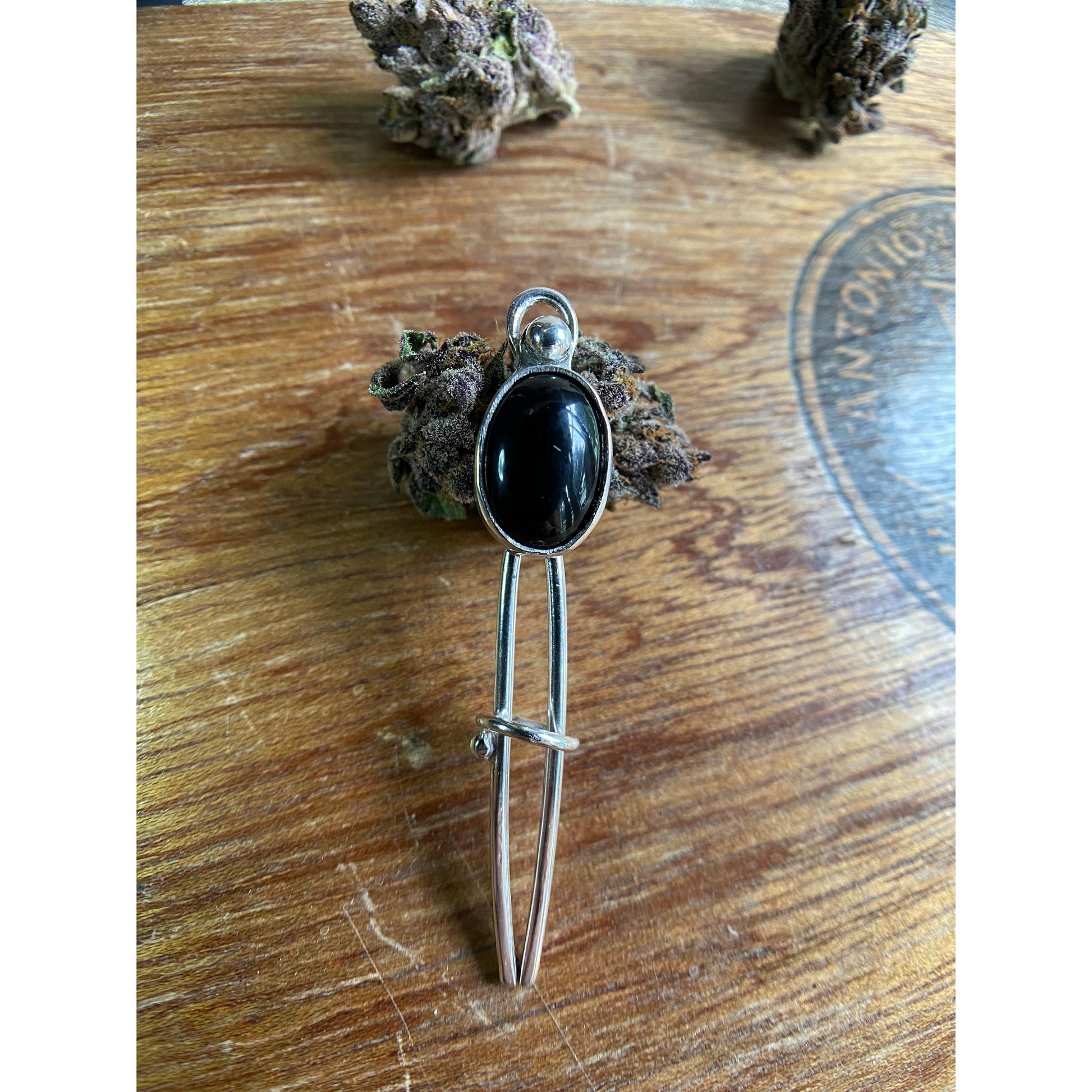 Black two prong hair fork with onyx set upon the top.