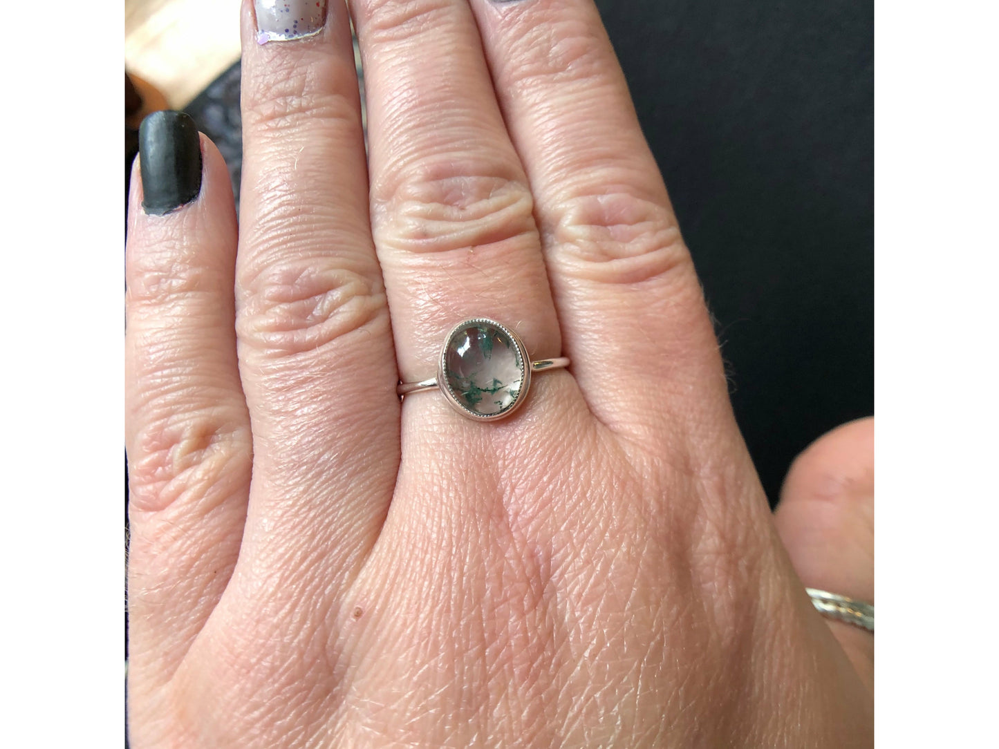 Tiny dots of moss surrounded in quartz, open back bezel with simple silver band
