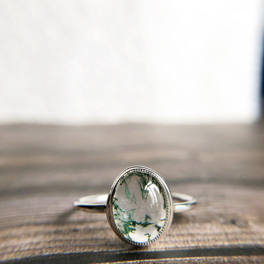 Tiny dots of moss surrounded in quartz, open back bezel with simple silver band
