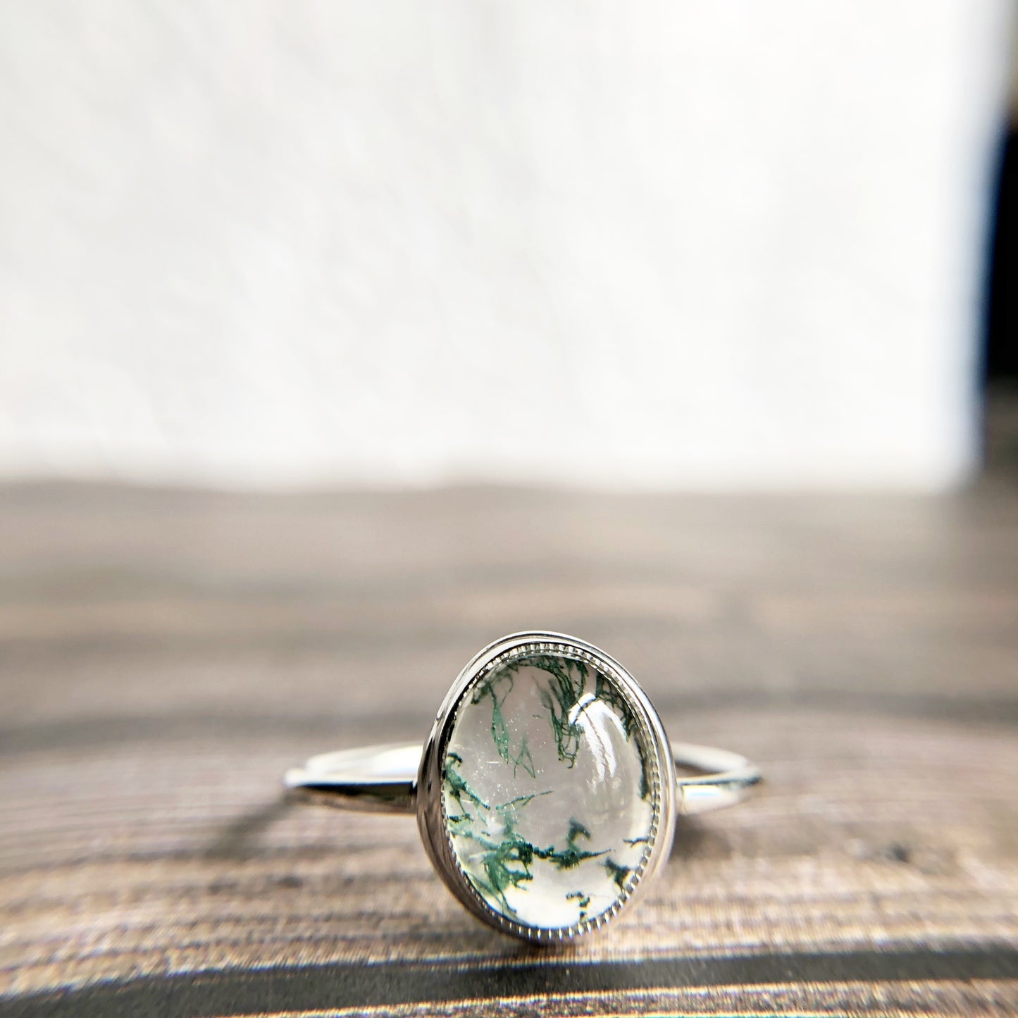 Tiny dots of moss surrounded in quartz, open back bezel with simple silver band