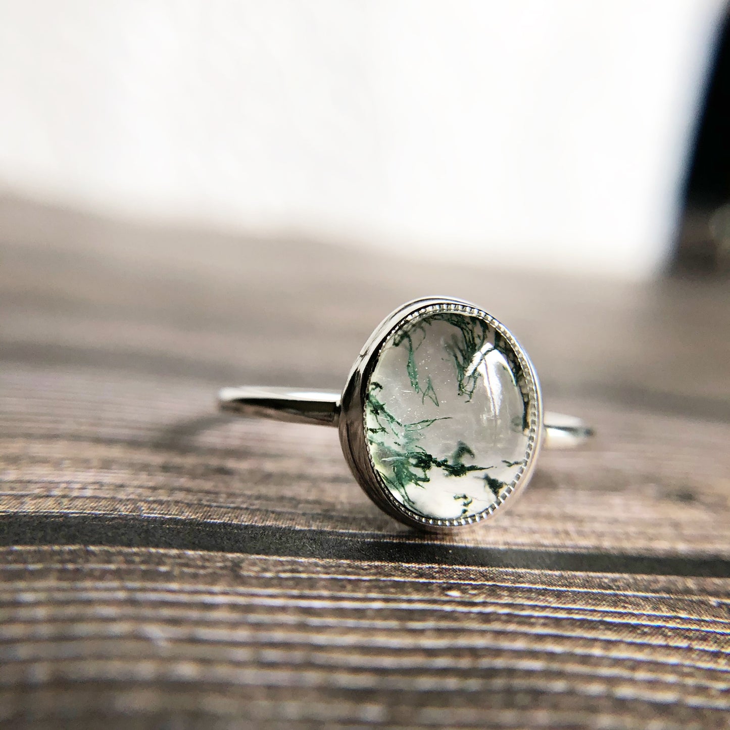 Tiny dots of moss surrounded in quartz, open back bezel with simple silver band