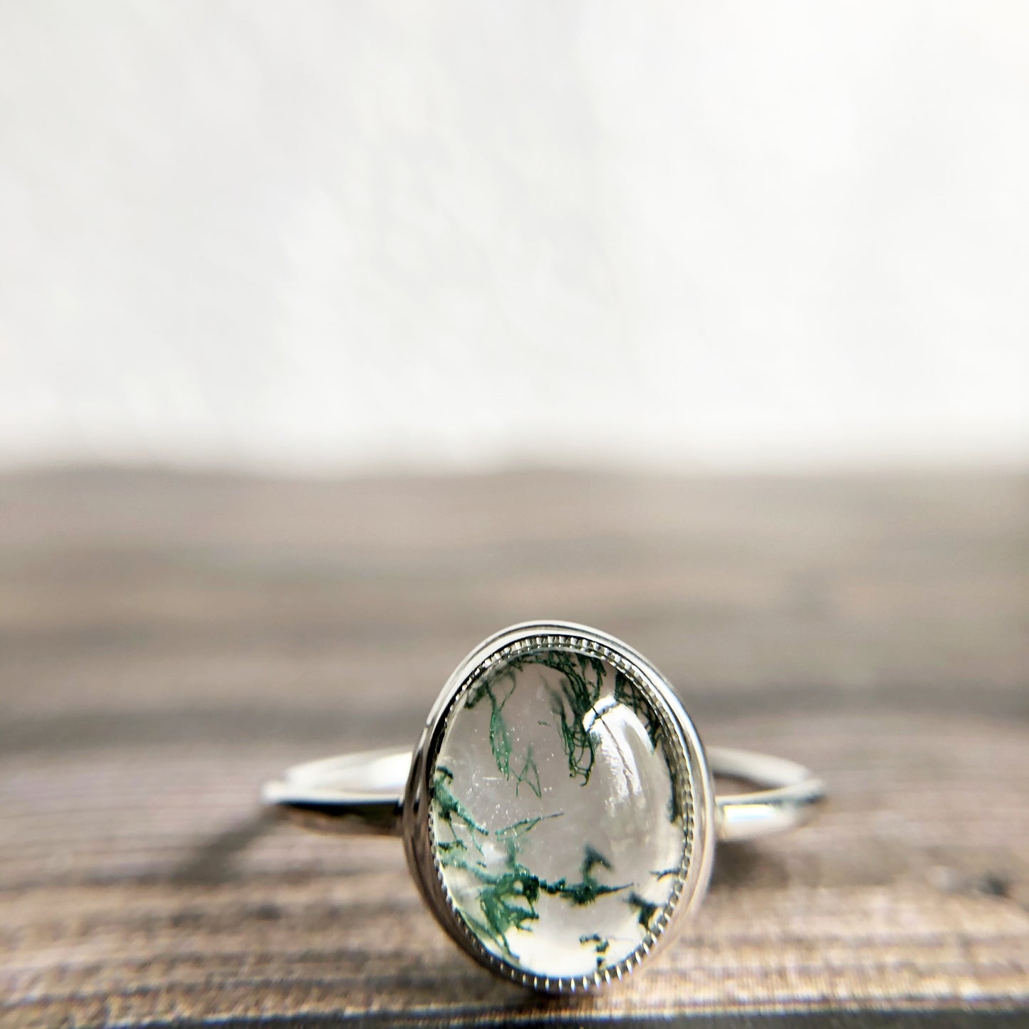 Tiny dots of moss surrounded in quartz, open back bezel with simple silver band