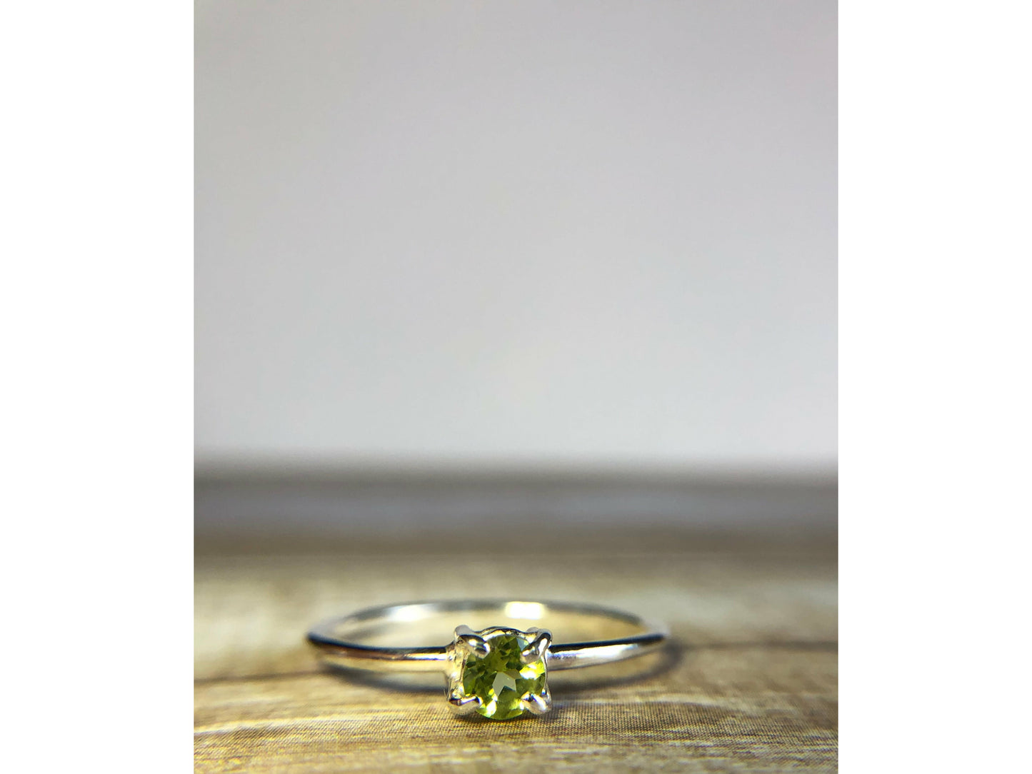 small green gemstone with simple band connecting to left and right side of stone.