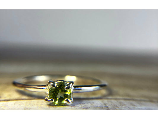 small green gemstone with simple band connecting to left and right side of stone.