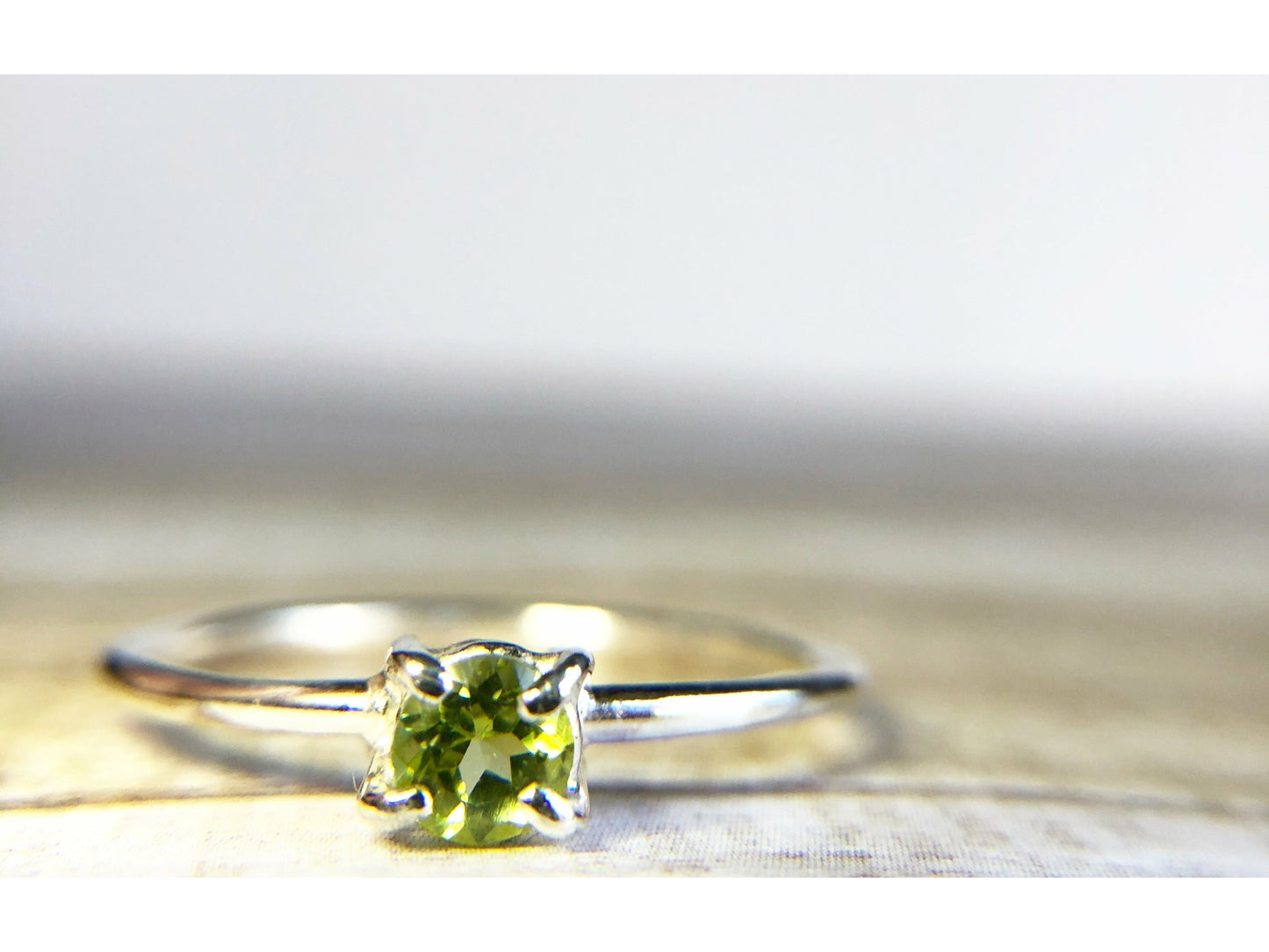 small green gemstone with simple band connecting to left and right side of stone.