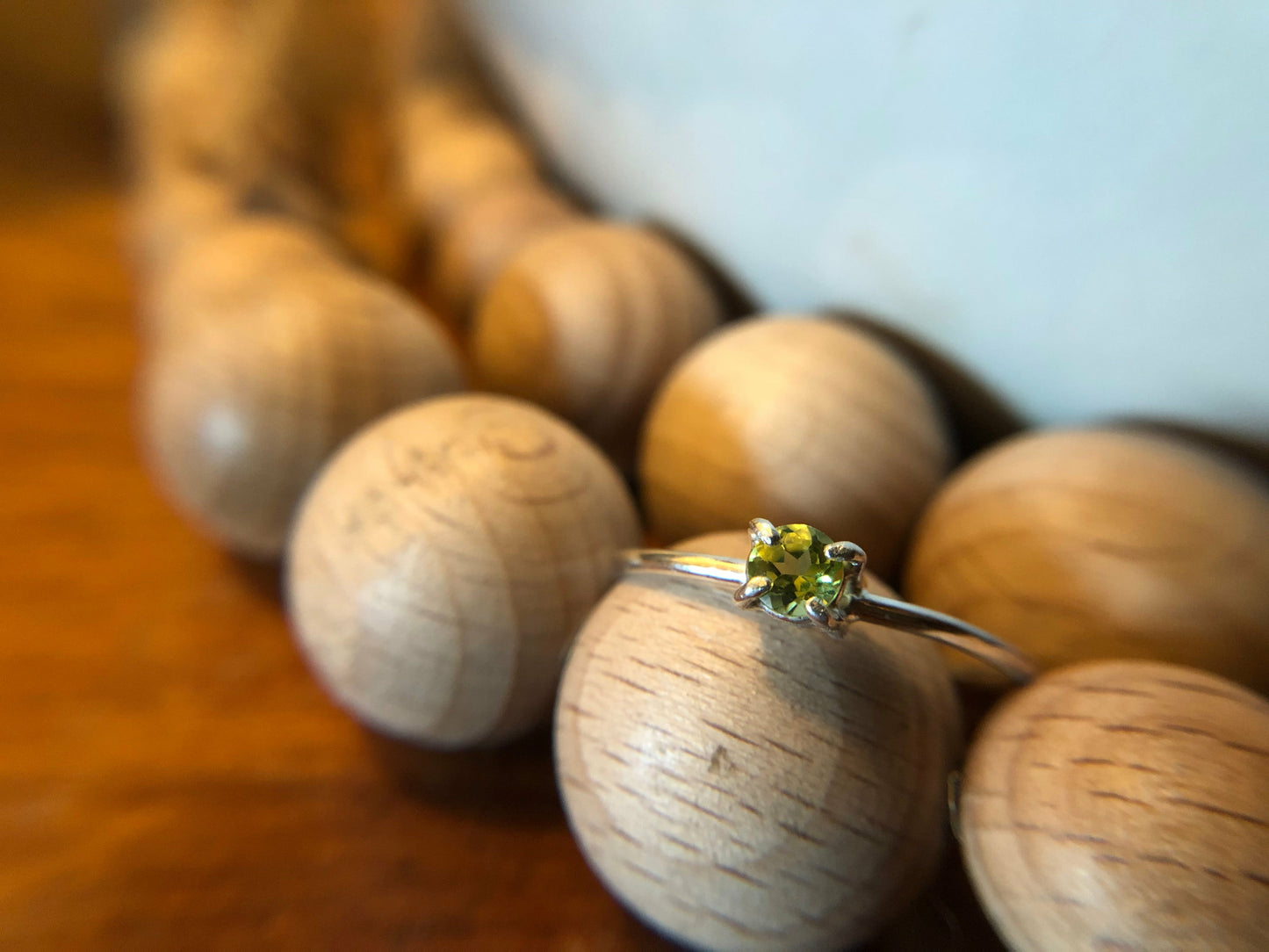 small green gemstone with simple band connecting to left and right side of stone.