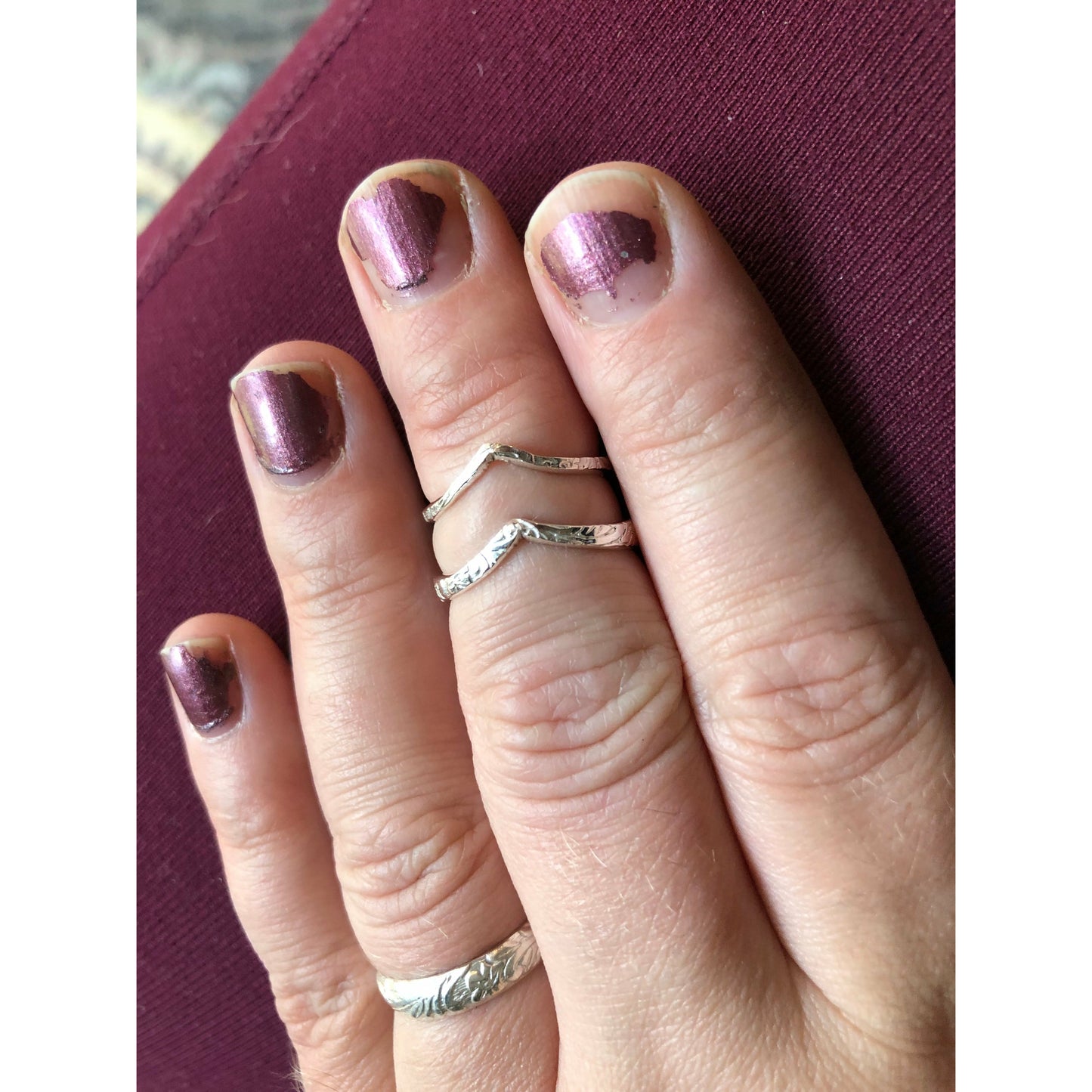 Patterned silver ring with chevron shape.