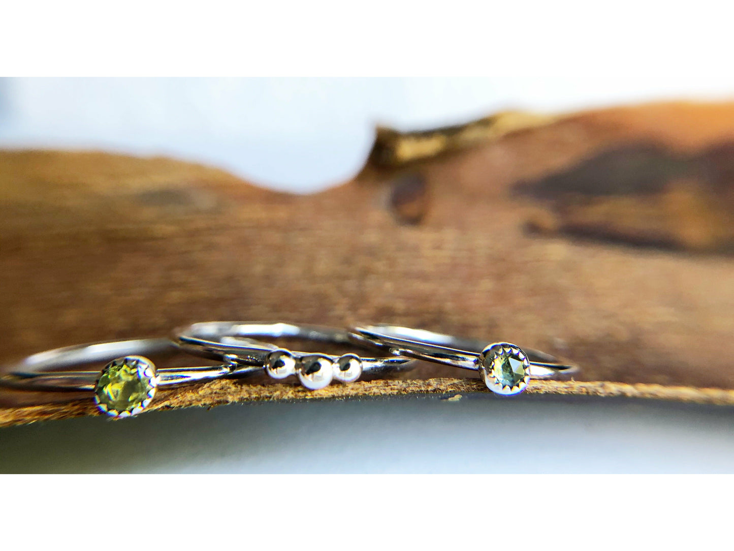 small dots of silver three in total as the focal of this rounded band ring.