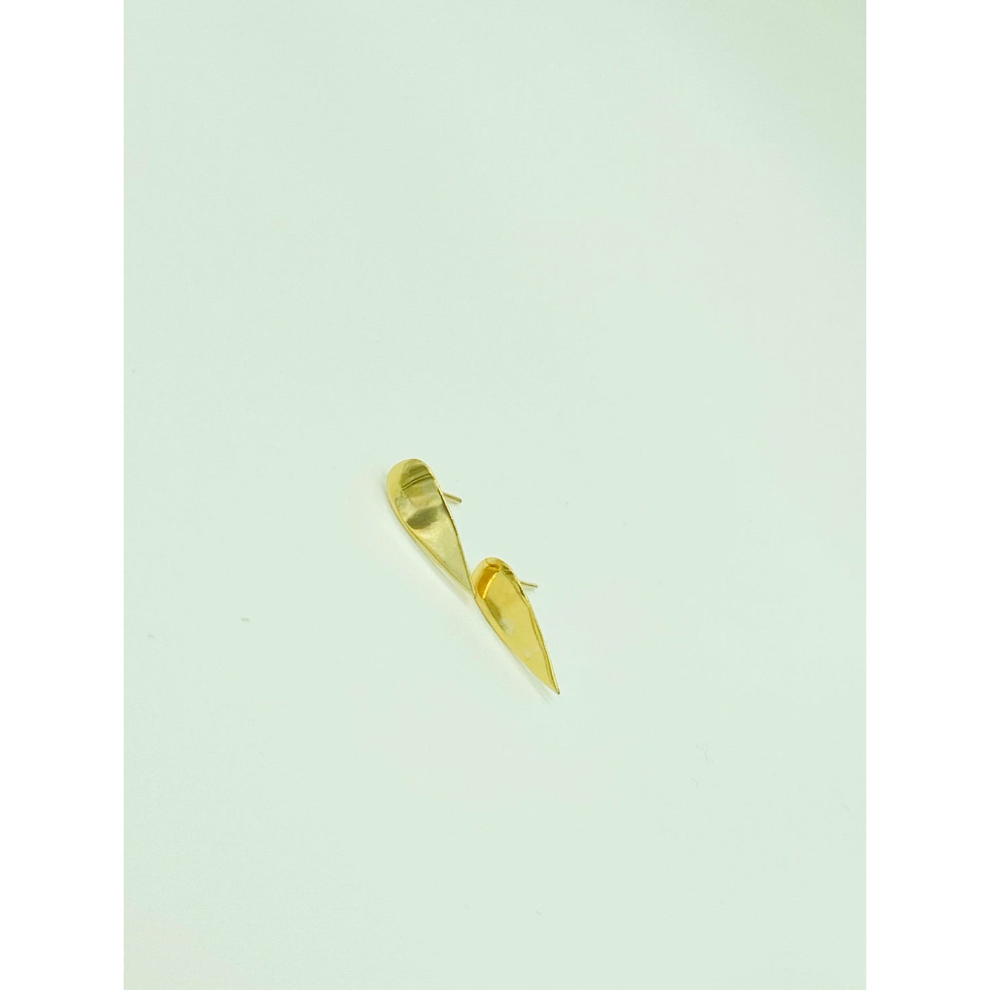 Gold spike earrings with point facing down.