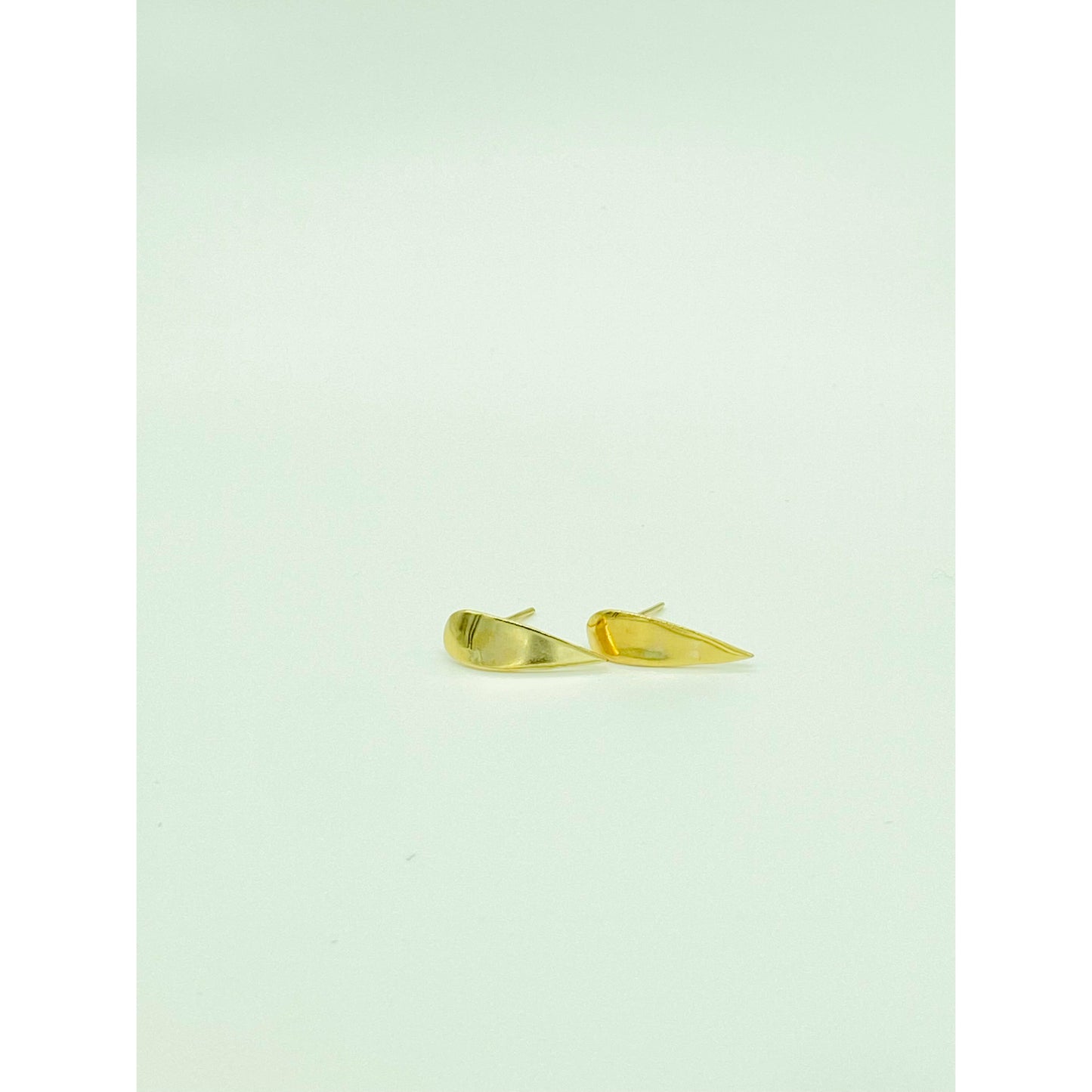 Gold spike earrings with point facing down.