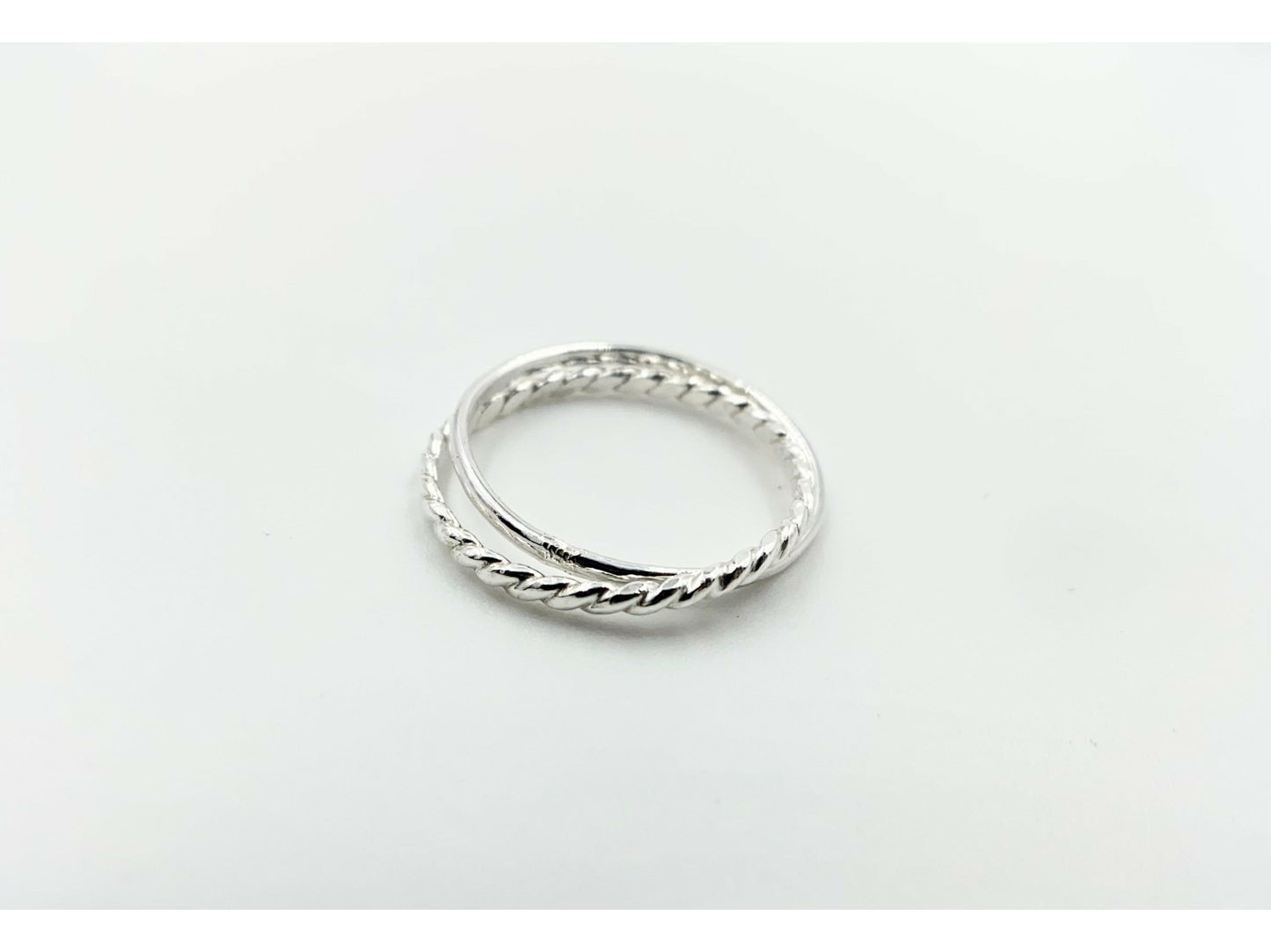 Two rings soldered together to create an illusion of rings stuck together. One plain band one twisted band