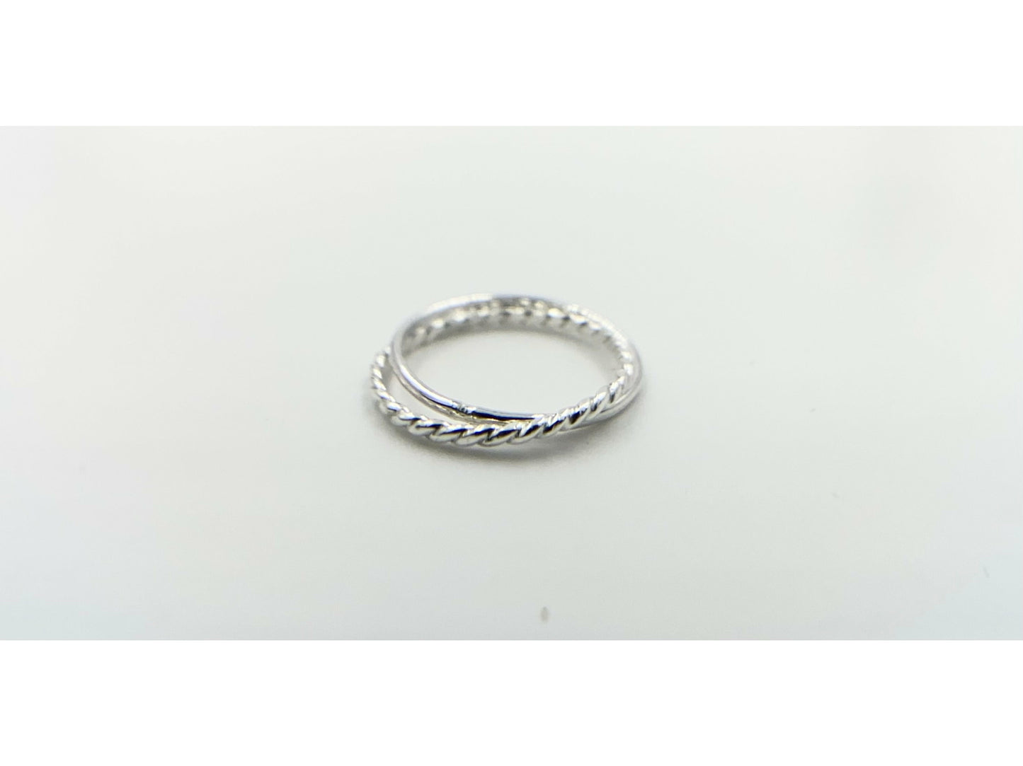 Two rings soldered together to create an illusion of rings stuck together. One plain band one twisted band