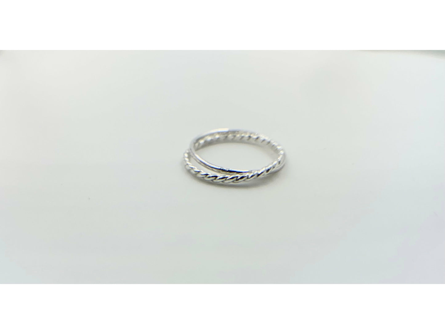 Two rings soldered together to create an illusion of rings stuck together. One plain band one twisted band