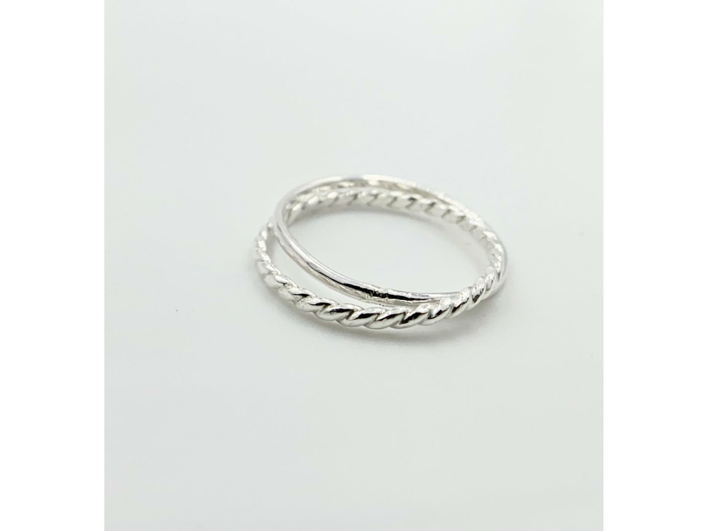 Two rings soldered together to create an illusion of rings stuck together. One plain band one twisted band