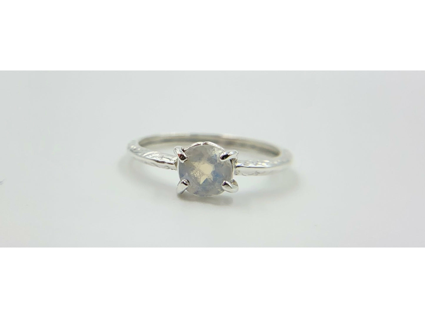 Moonstone prong set into a square simple band.