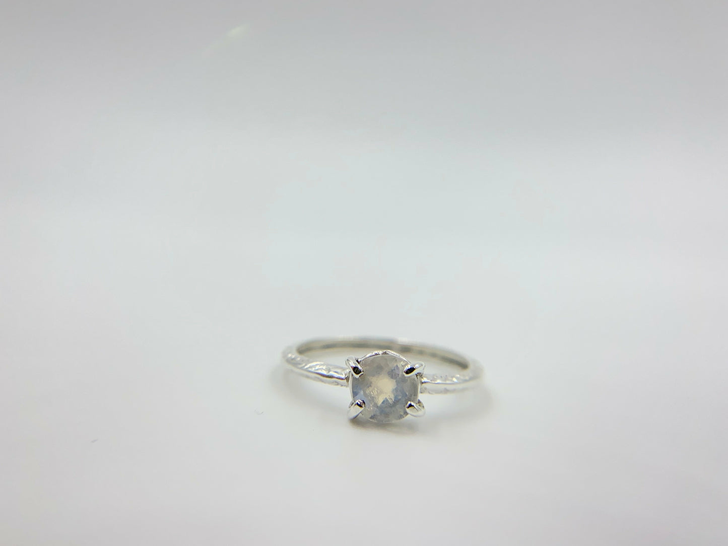 Moonstone prong set into a square simple band.