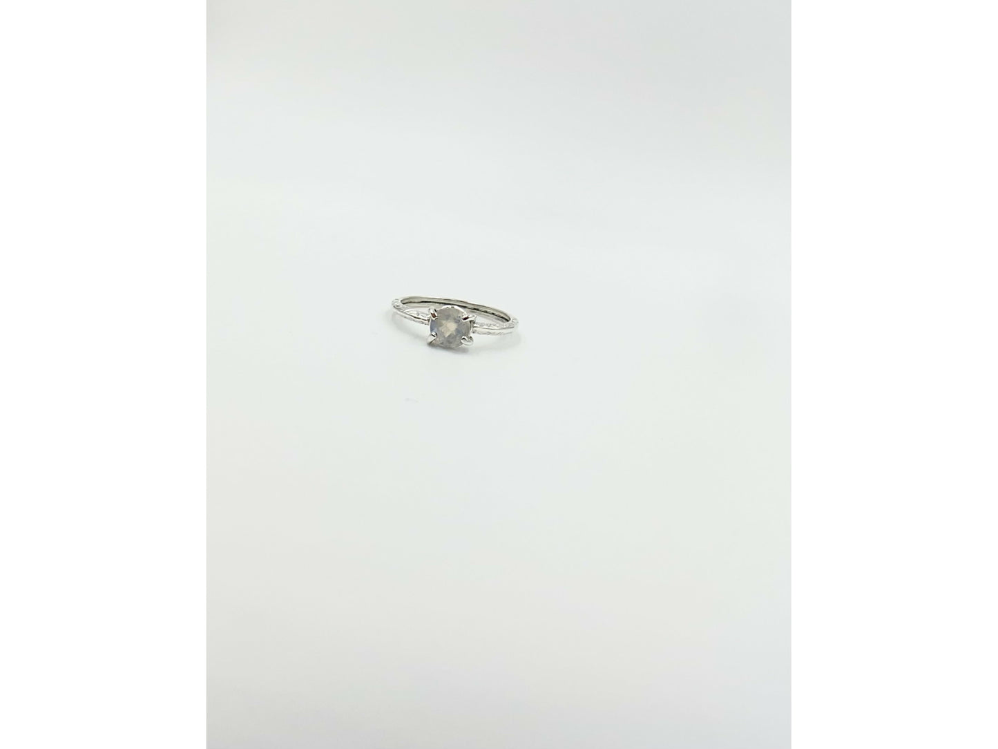 Moonstone prong set into a square simple band.