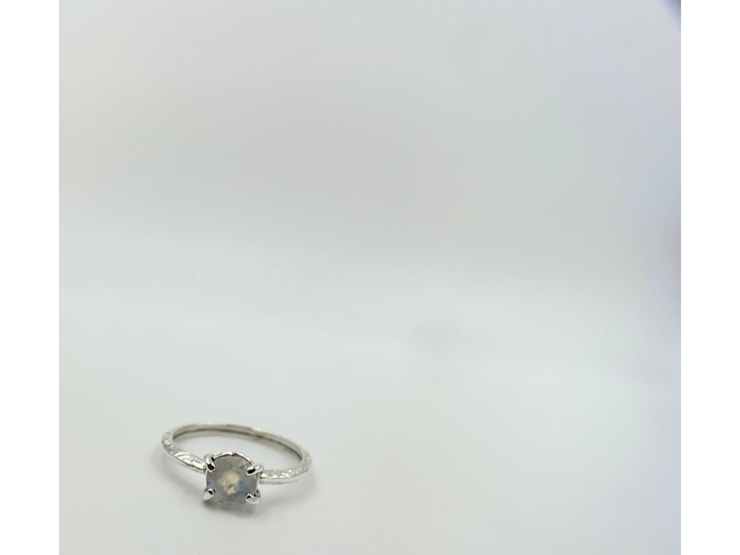Moonstone prong set into a square simple band.