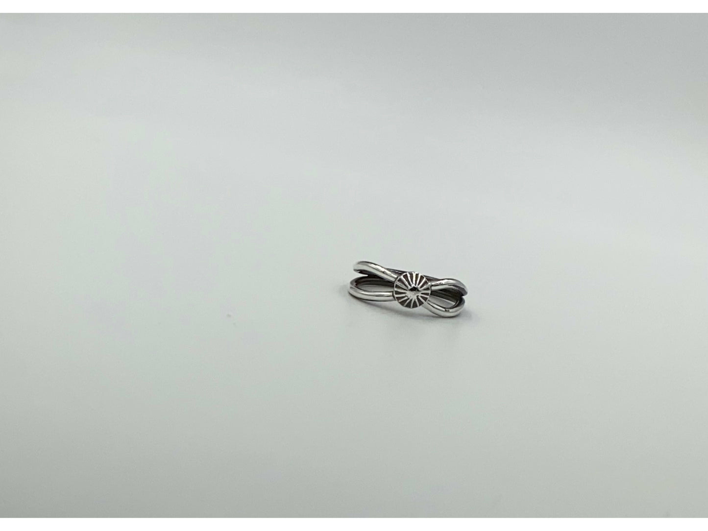 Split shank ring with center focal of a spiral ornated silver pendent. Small and dainty