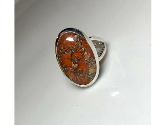 Orange, yellow and oranges grace this oval ring mounted to a simple yet sturdy band