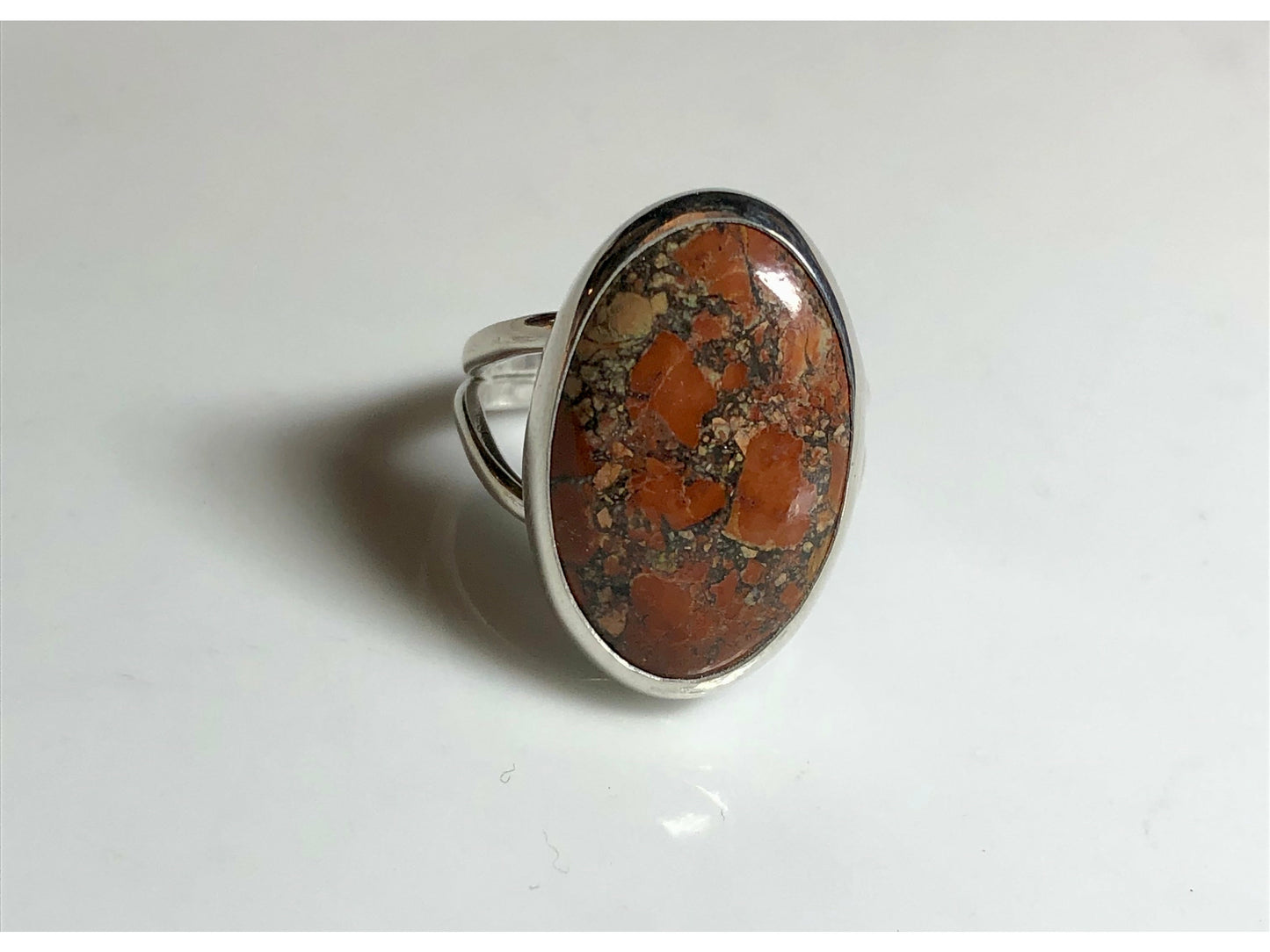 Orange, yellow and oranges grace this oval ring mounted to a simple yet sturdy band