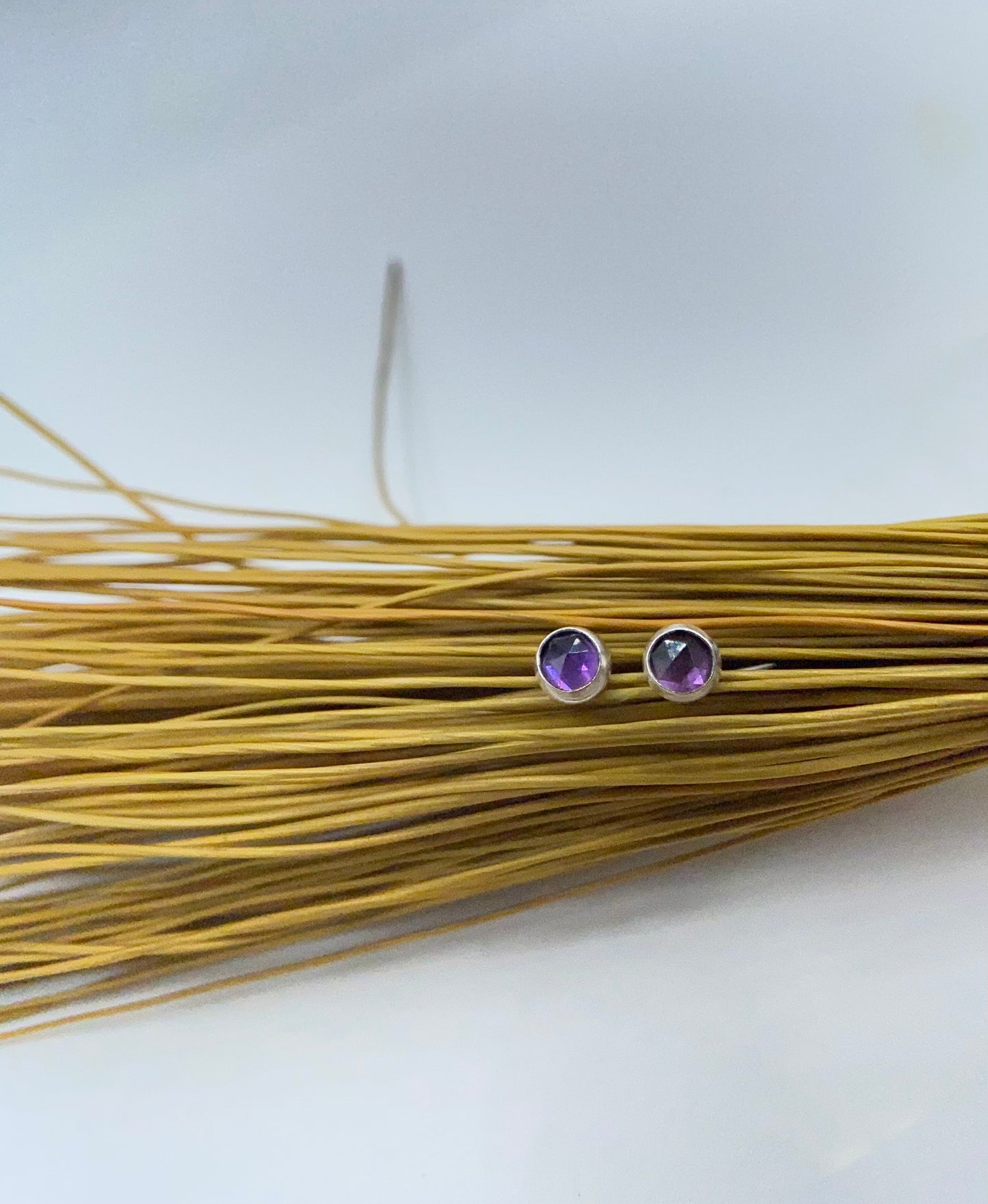 Small amethyst studs with closed back bezel.