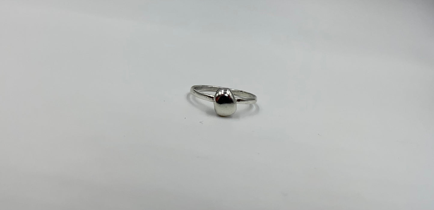 Organic sterling silver ring with large bump of silver resembling a raindrop as the focal, super simple straight band.