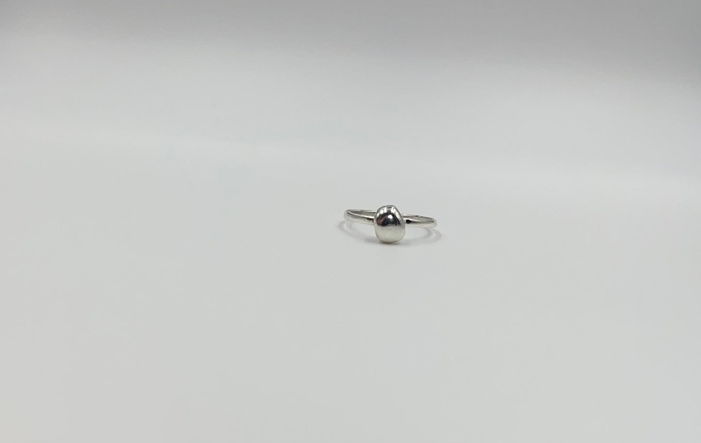 Organic sterling silver ring with large bump of silver resembling a raindrop as the focal, super simple straight band.