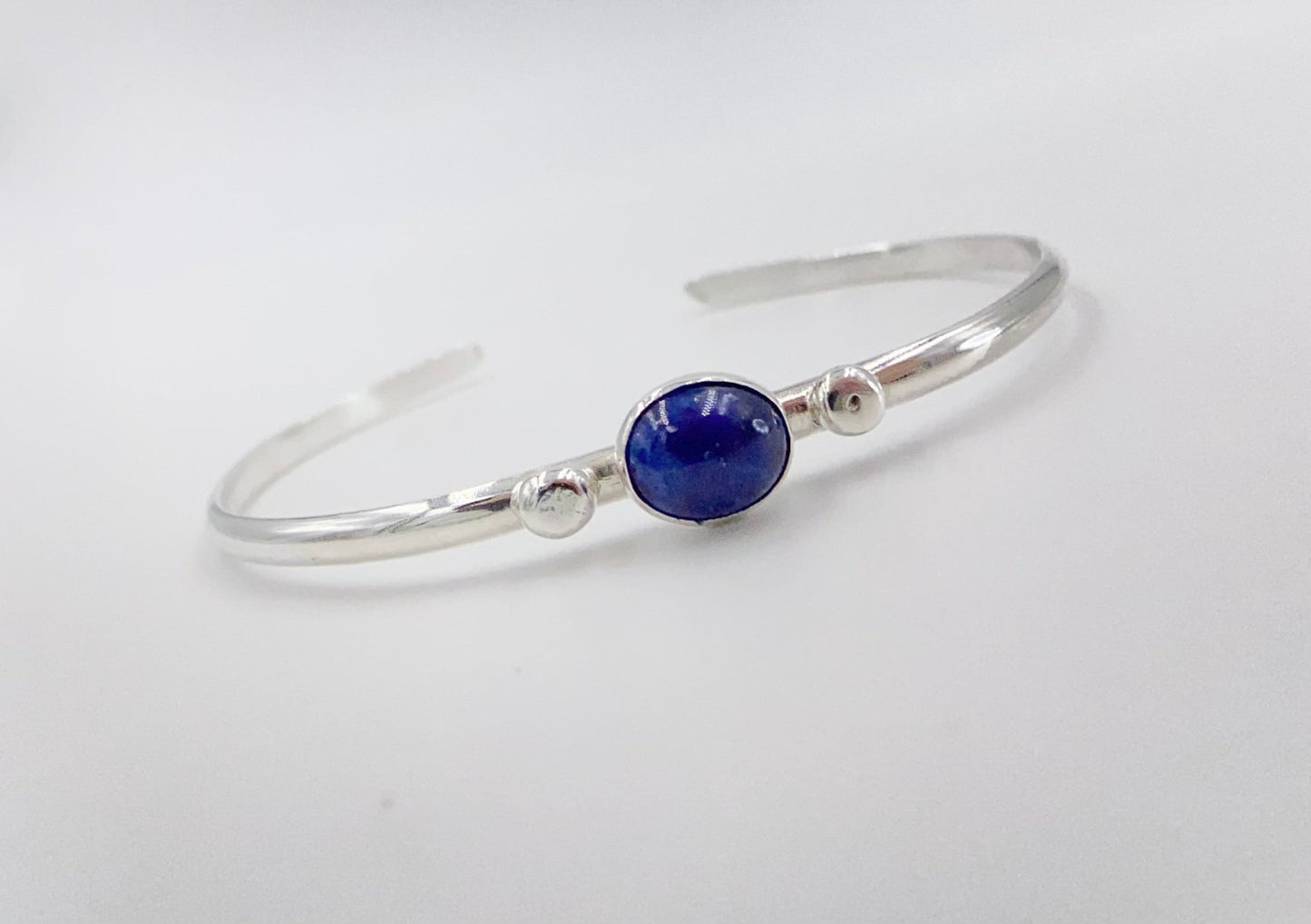 Stacakble cuffs with onyx, lapis or just a plain bracelet. Ornate pieces of silver dot the pieces as well as a oval stone.