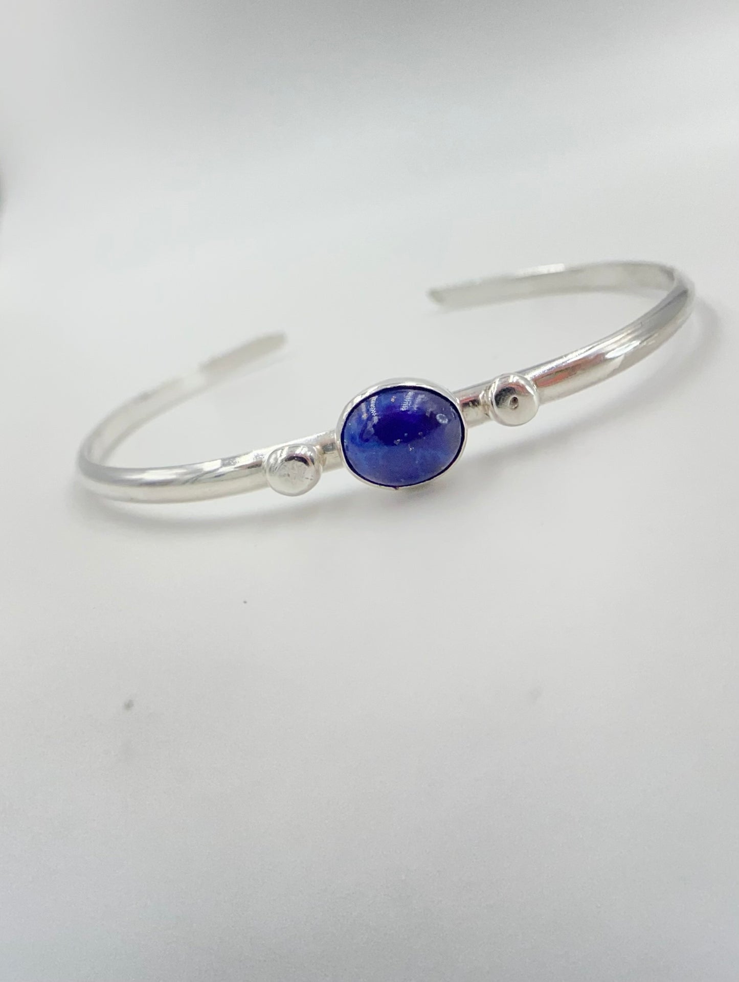 Stacakble cuffs with onyx, lapis or just a plain bracelet. Ornate pieces of silver dot the pieces as well as a oval stone.