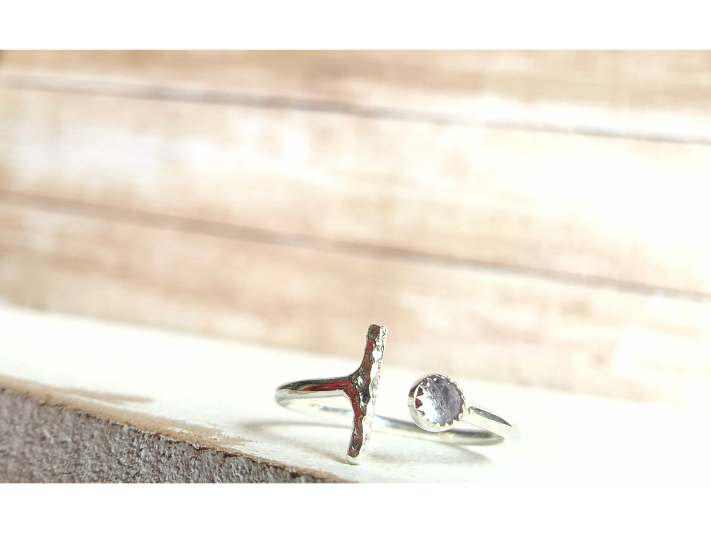 One side has a silver bar, other side of adjustable ring has a small stone purple in it.