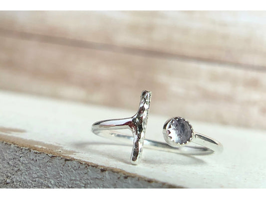 One side has a silver bar, other side of adjustable ring has a small stone purple in it.