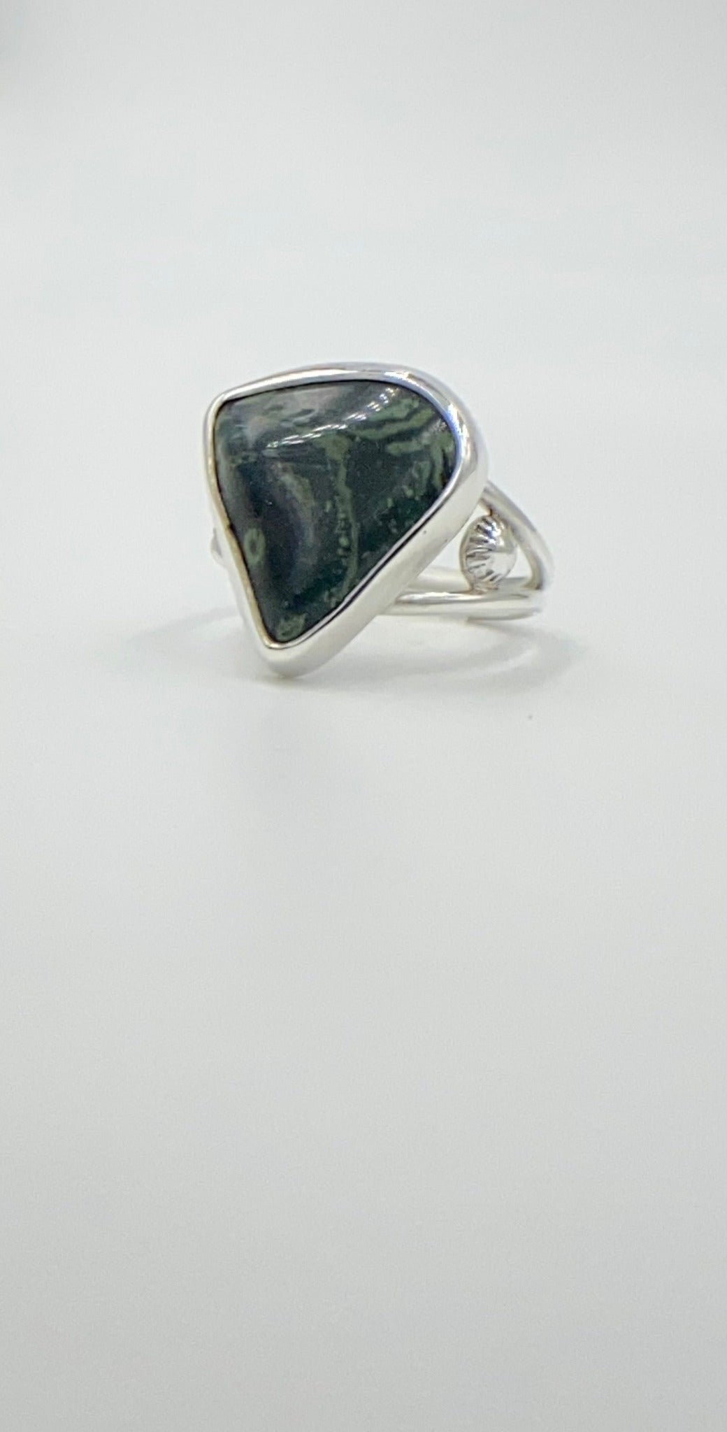Malachite triangle cabachon mounted an a round profile band. Pieces of ornate granulation surround on the left and right.Split shank band.